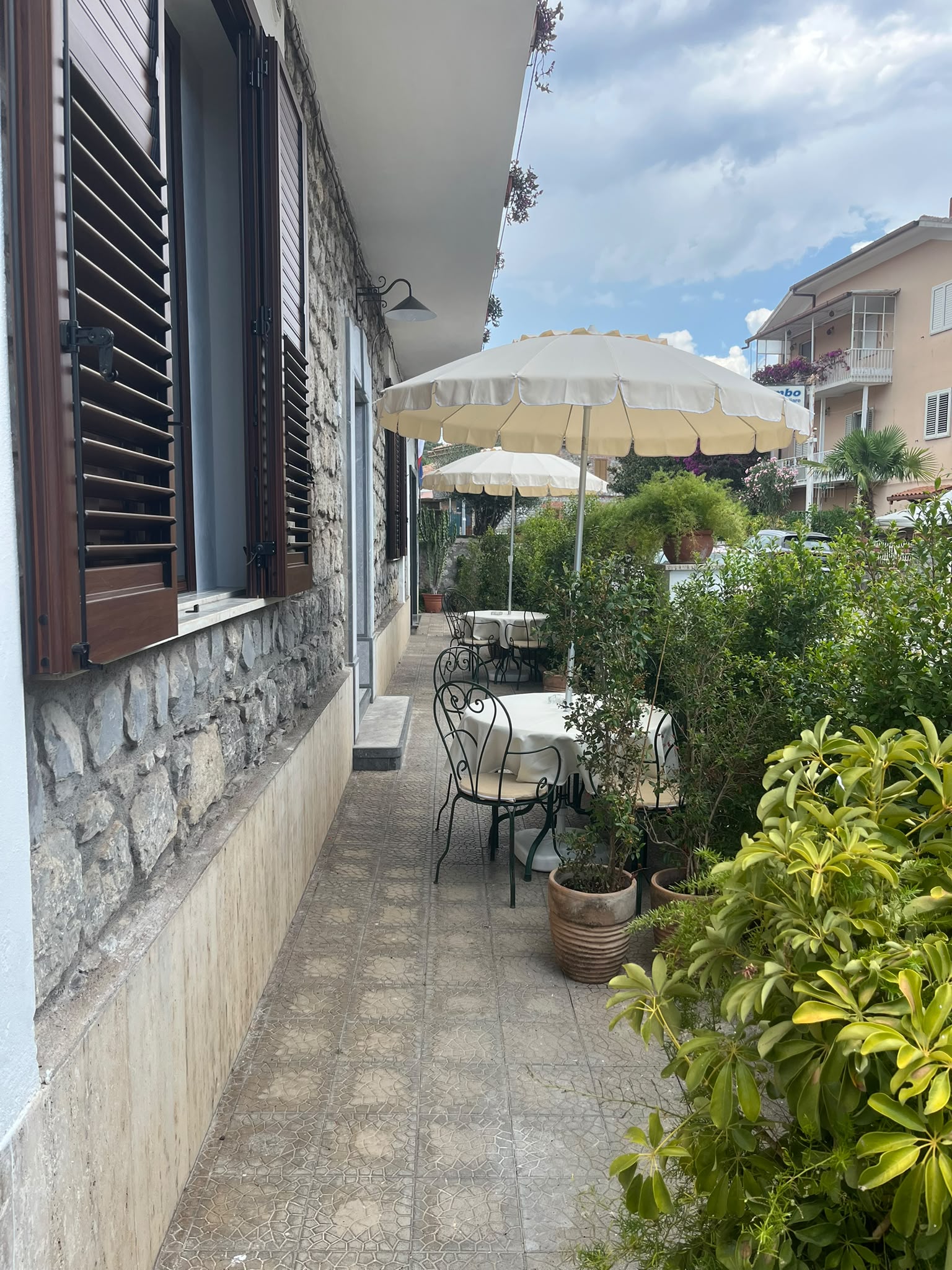 Patio esterno con tavoli e ombrelloni di Dimora Patrizia a Scario Cilento